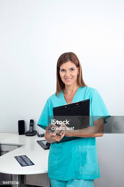 Female Dentist Holding Clipboard In Clinic Stock Photo - Download Image Now - Adult, Adults Only, Cheerful