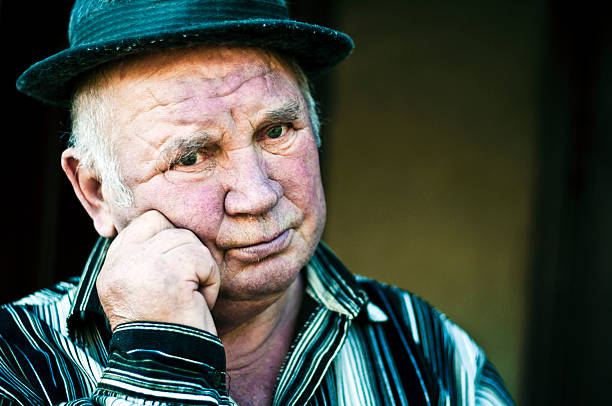 istock old man keeps his hand near the face 154973190