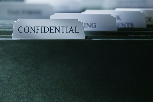 A file folder containing confidential documents photographed with a very shallow depth of field.