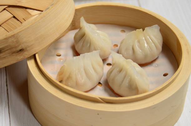 istock A wooden container filled with dumplings sitting on top of a table 1549824920