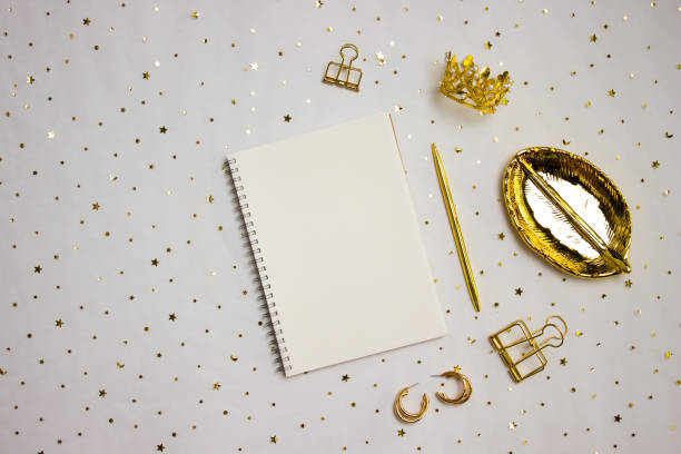 istock A notebook with golden items over the golden background. 1549841079