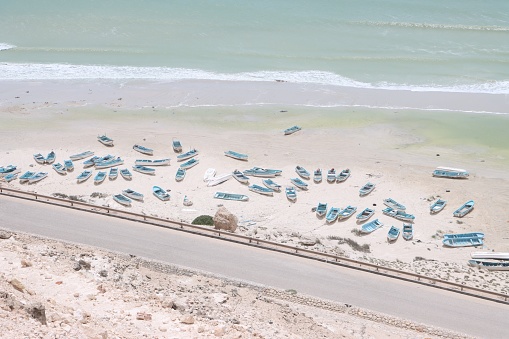 Local Indonesian fishermen in Bali work their through the massive plastic pollution on the beach of Jimbaran. The pollution is caused by the monsoon season and the lack of environmental development.