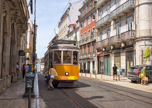 Lisbon, Portugal - Street view of Bairro Alto district on a summer afternoon. A yellow Tram and people and cars can be seen.
