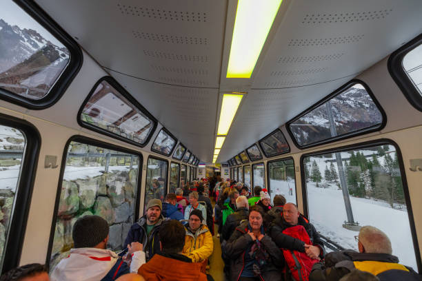 wengen, svizzera, 13.1.2023: molte persone in un'auto panoramica della ferrovia a cremagliera della jungfrau salgono sulla cima della montagna. - switzerland cold green rock foto e immagini stock