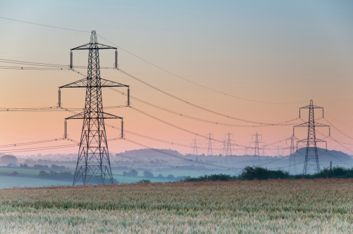 Electricity pylons and lines above farmland , England