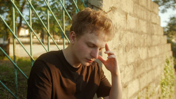 istock Overwhelmed by Stress: Blond Man Outdoors, Holding His Head and Expressing Distress 1549978861