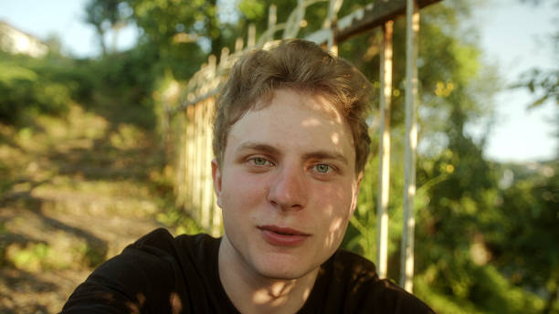istock Connect and Smile: Young Handsome Blond Man with Colored Eyes Engaging in a Video Conference, POV Perspective 1549982007