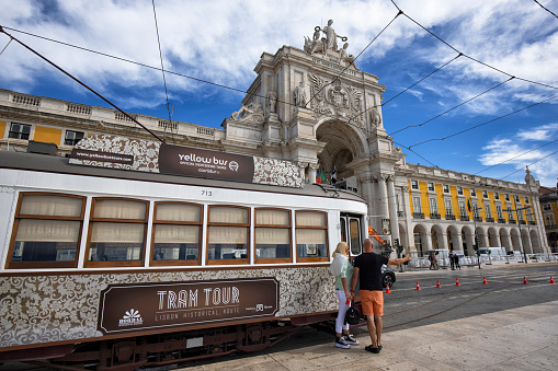 Lisbon, Portugal - View of Praça do Comércio on a summer afternoon. A tram car and tourists can be seen and Arch of Rua Augusta in the background.
