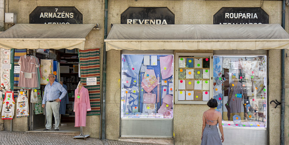 Lisbon, Portugal - Street view of Baixa district on a summer afternoon. A clothing shop and people can be seen.