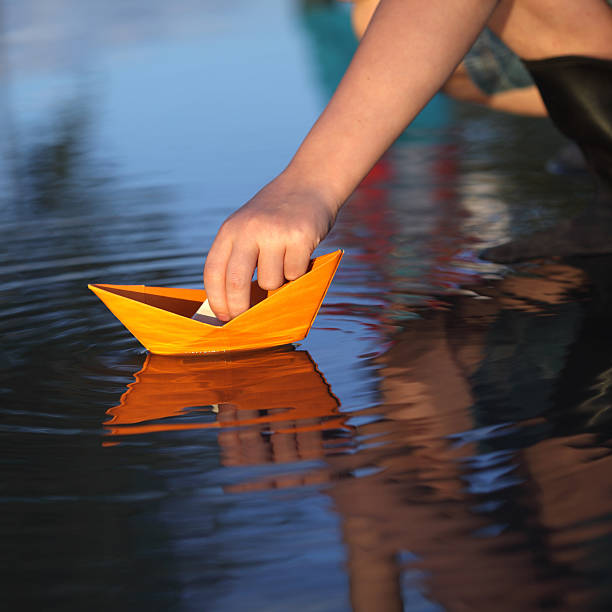 istock paper ship in children hand 154999138