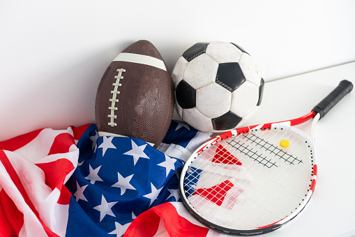 Various sport equipment for baseball, football, soccer and fishing on vintage wooden USA flag . High quality photo