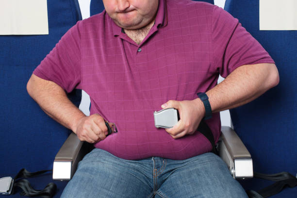 homem com excesso de peso em um avião - abdomen too small jeans overweight - fotografias e filmes do acervo