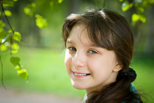 Woman beautiful smile with teeth in the spring on a sunny day happy in nature against the backdrop of green grass, the concept of female body health without allergies. High quality photo