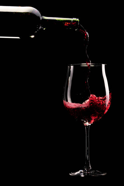 赤ワイングラスに注がれるを - wine pouring wineglass red ストックフォトと画像