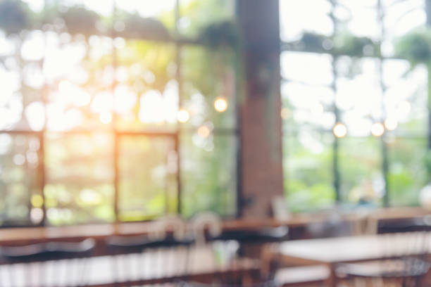 verschwommener hintergrund: café, café, restaurant im einkaufszentrum mit leichtem bokeh, geschäftsevent, einzelhandelsgeschäft. verschwommener hintergrund, innenarchitektur, bartisch, stuhl, fenster schmücken die anzeige des innenraums - fokus auf den vordergrund stock-fotos und bilder