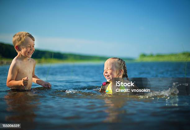 Niños Jugando En Un Río Foto de stock y más banco de imágenes de Lago - Lago, Niño, Natación