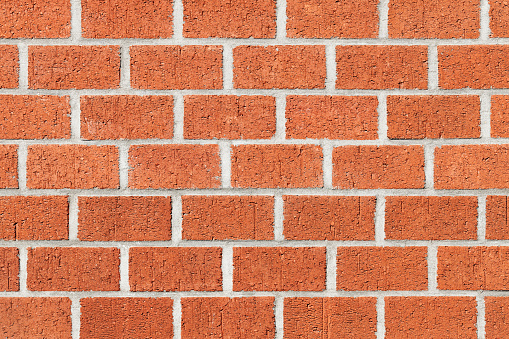 A shot of a brick wall. This wall has an old classic and country look. It is brown with the hint of orange much like the wall that is used in country and farm houses. The brick's brown color is a result of the color of the mud that is made of, make it natural feel.