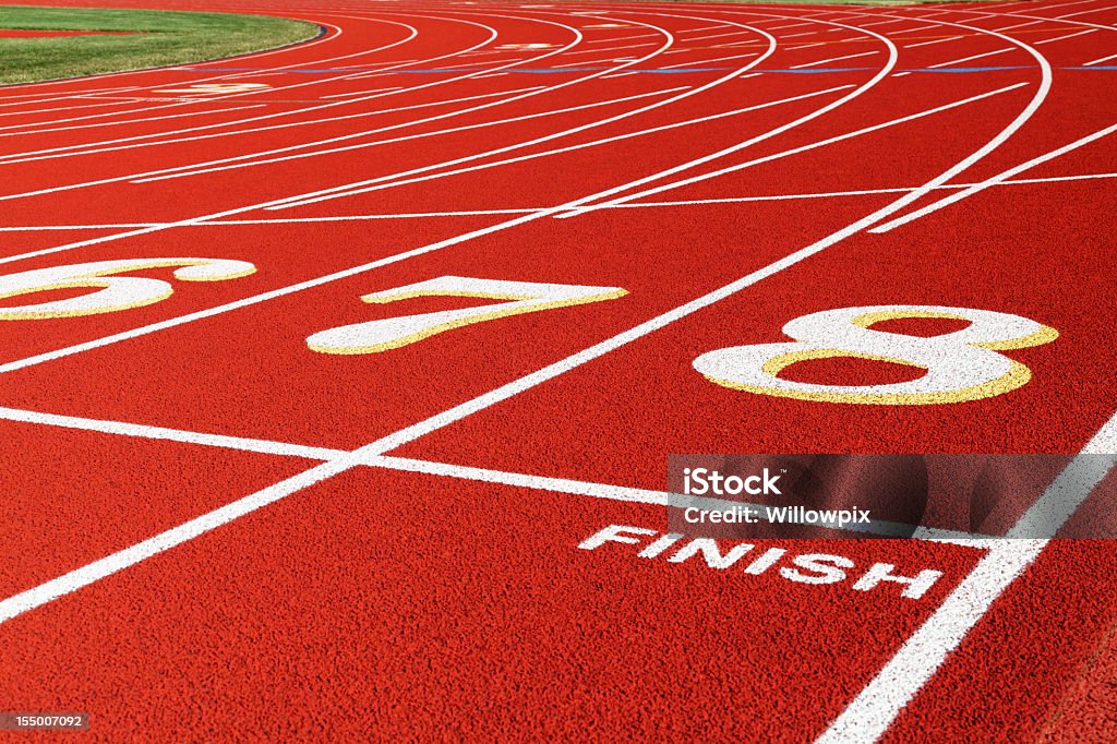 Finish Line vías rojo corriendo en la pista de carreras en primer plano - Foto de stock de Línea de meta libre de derechos