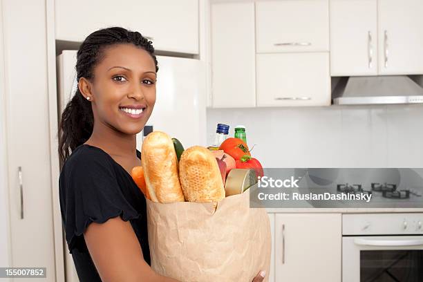 Woman Holding Bag With Grocery Products At Kitchen Stock Photo - Download Image Now