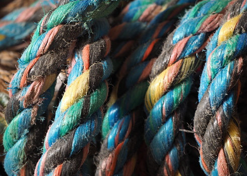 Ropes wrapped around an old, weathered beam. In the background green water of a lake