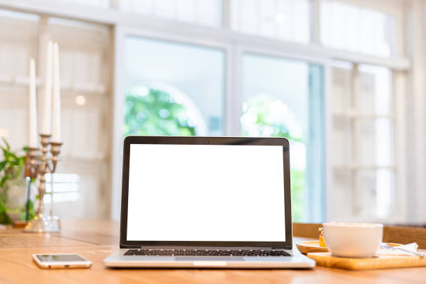 istock Mockup of laptop computer with empty screen with coffee cup and smartphone on table of the coffee shop background,White screen 1550110757