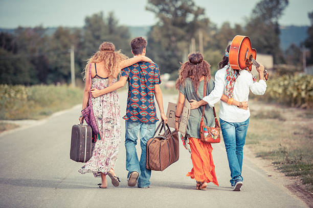 groupe de hippie marchant sur une route de campagne - 1970s style women hippie retro revival photos et images de collection