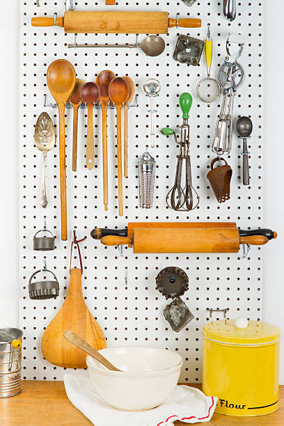 panneau vertical perforé plein de gadgets de cuisine - pegboard photos et images de collection