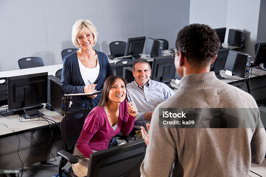 Adulto alunos ouvindo o instrutor em um computador de sala de aula - Foto de stock de Biblioteca de Informática royalty-free