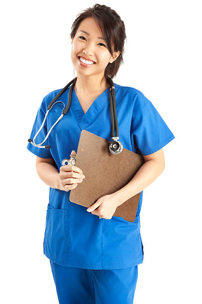 Cheerful Young Asian Nurse in Blue Scrubs stock photo