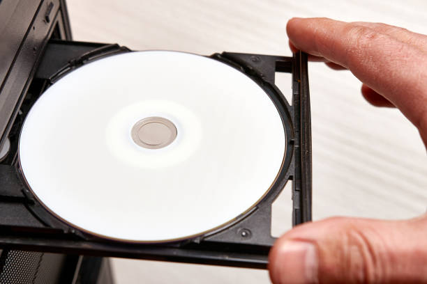 istock A man inserts a disc into a disc player on his computer. Technologies of information carriers of CD, DVD, BD format. 1550137065