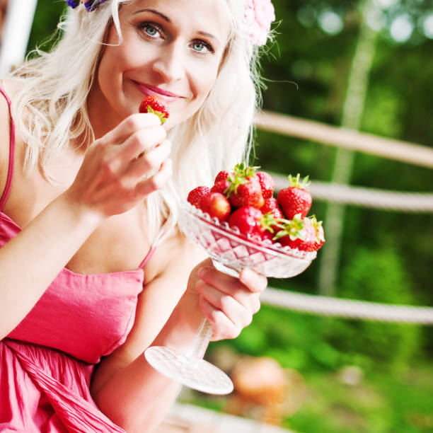 istock woman eating strawberries 155013912