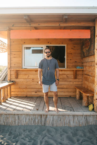 istock Man standing in front of a log cabin 1550139755