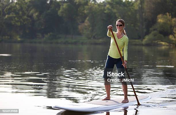 Mujer Atlética De Remo En Un Tranquilo Lago De La Región Central De Estados Unidos Foto de stock y más banco de imágenes de Paddleboard