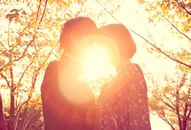 Young couple hugging in the nature during summer sunset.