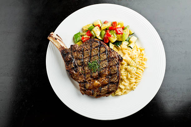 costeleta de vaca com macarrão e queijo - steak grilled beef plate imagens e fotografias de stock