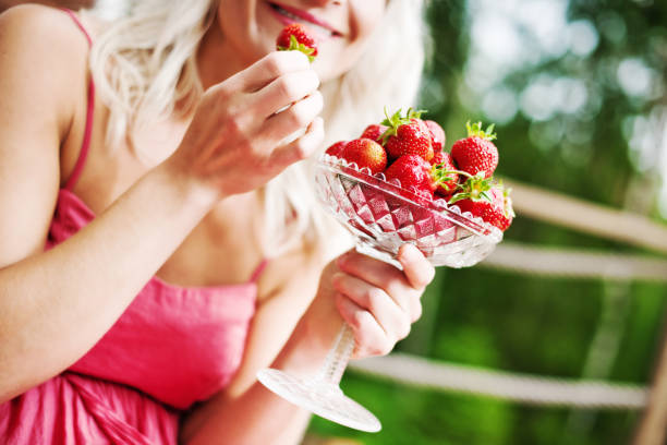 istock woman eating strawberries 155014640