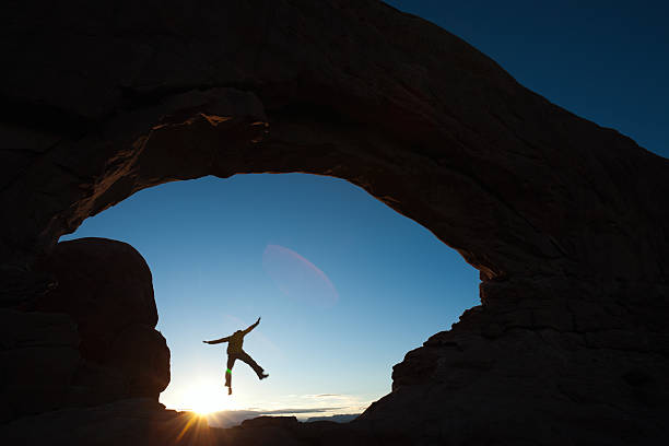 Jumping through South Window Arch.  leap of faith stock pictures, royalty-free photos & images