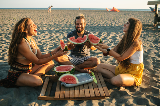 A group of people toasting with watermelon