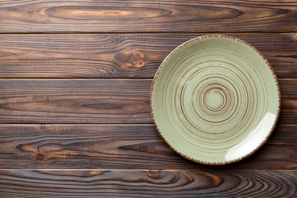 istock Top view of empty green plate on wooden background. Empty space for your design 1550169259