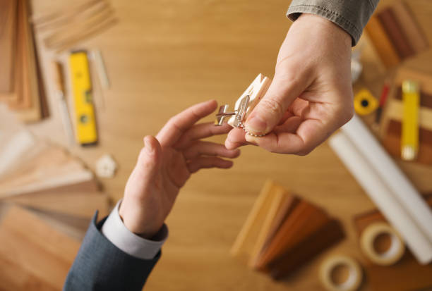 istock Real estate agent giving house keys 1550177309