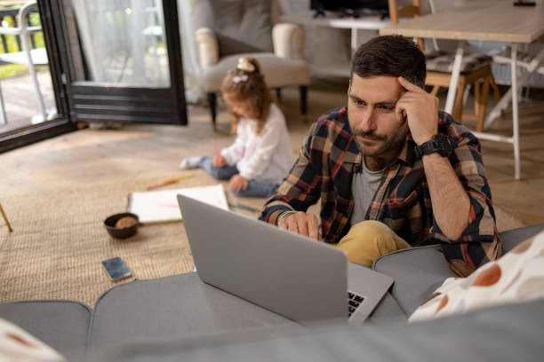istock Single father working on laptop in the living room. 1550183735