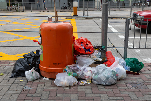 Hong Kong - July 17, 2023 : An overflowing rubbish bin on a street in Hong Kong.