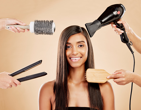 Hair, electric tools and portrait of woman for beauty options on studio background. Happy indian female model with choice of aesthetic salon equipment with brush, hairdryer and flat iron for makeover