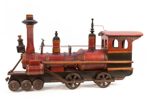 A very old toy train made of wood and cast iron.