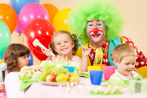 children celebrating birthday party with clown