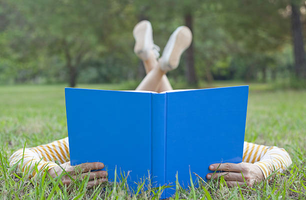 istock Girl reading book on grass 155023935