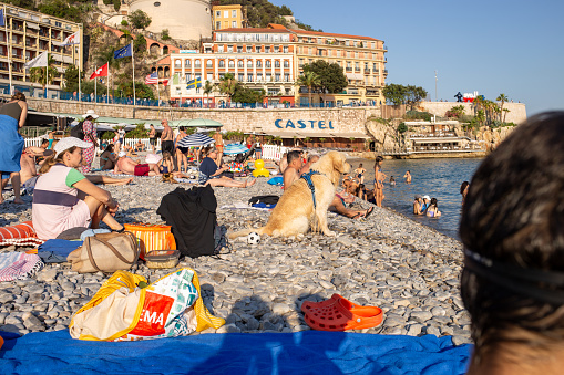 Nice, france - 12 July 2023 - Castel beach Nice France. people and dog sunbathing on the beach