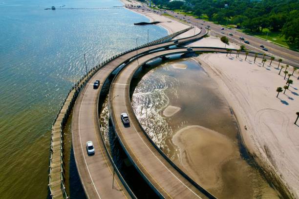 istock Cars driving along a highway bridge, which is elevated above the water below. 1550246896