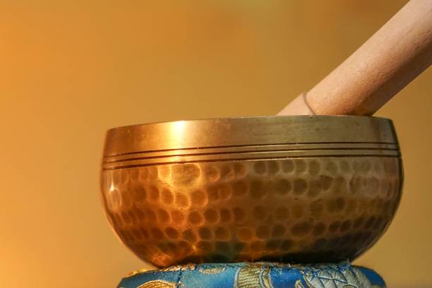 istock Ornate, hand-hammered Tibetan bell on a golden background 1550257442