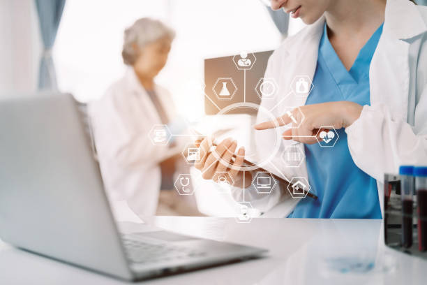 istock Medical Research Laboratory: Two scientists working, using digital tablets and laptop, analyzing samples, talking, developing biotechnology. 1550284079
